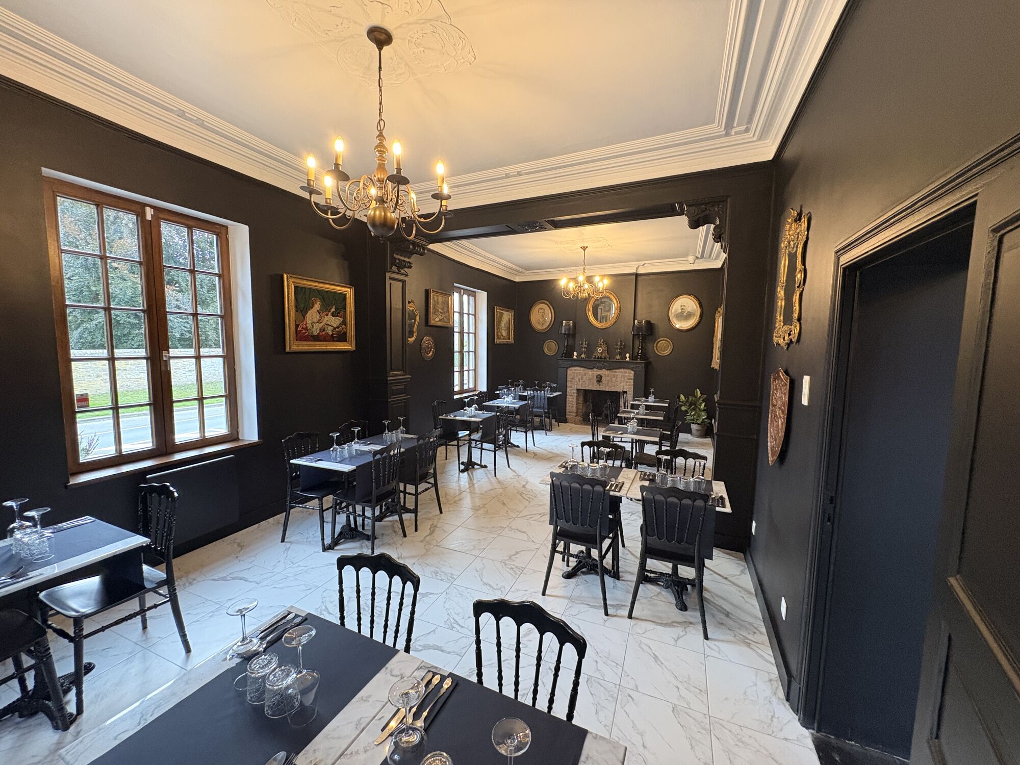 Salle de La Toque Noire Ristorante sous le lustre, tables dressées près de la fenêtre